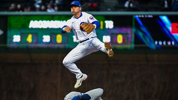 Nico Hoerner throws the ball to first base.